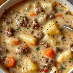 a white bowl filled with meat and potato soup