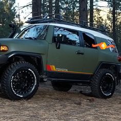 a green toyota truck parked in the woods