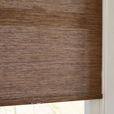 a brown roman blind in a window