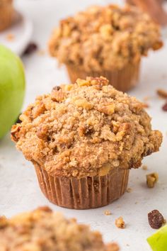 some muffins are sitting next to an apple