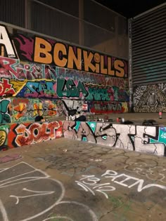 a skateboard park with graffiti all over the walls and flooring on it's sides