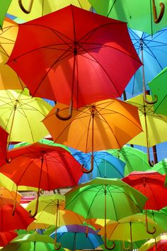 many colorful umbrellas are hanging in the air