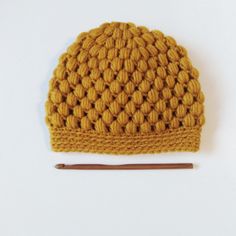 a crocheted hat with a knitting needle next to it