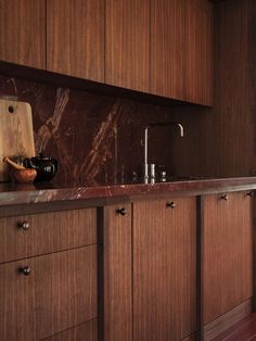 a kitchen with wooden cabinets and marble counter tops