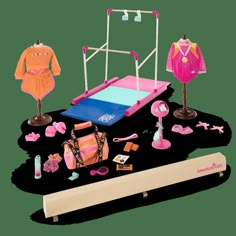 an assortment of children's clothing and accessories on a white surface with a wooden stand