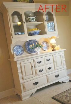 a white china cabinet with blue and white plates on it