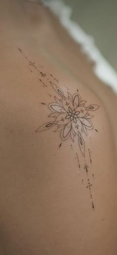 a woman's back with a flower tattoo on it