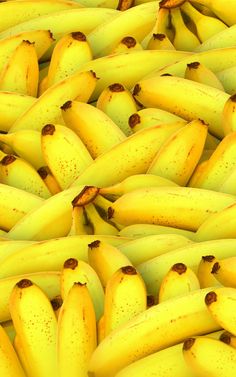 bunches of yellow bananas are piled together