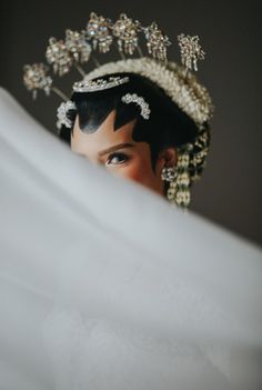 a woman wearing a tiara looking over her shoulder