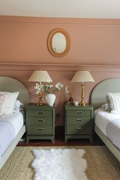 two green nightstands in a bedroom with pink walls and white fur on the floor