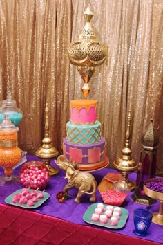 a table topped with lots of different types of cakes and candies next to gold sequins