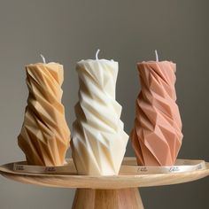 three candles sitting on top of a wooden tray