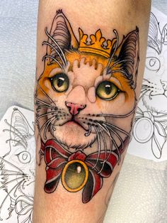 a cat with a crown on it's head is shown in this tattoo design