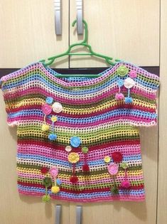 a colorful crocheted sweater hanging on a hook