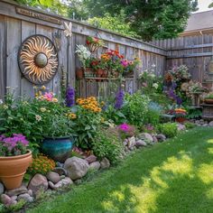 an outdoor garden with flowers and plants growing on the side of a fenced in area