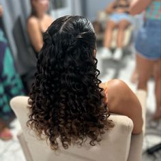 the back of a woman's head as she sits in a chair with other women