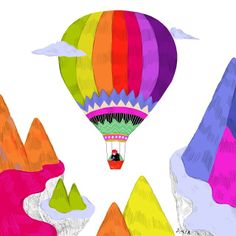 a colorful hot air balloon flying over mountains