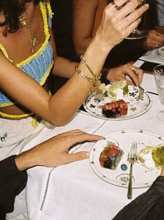 people sitting at a table with plates of food