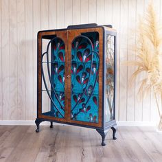 an old fashioned wooden cabinet with stained glass doors