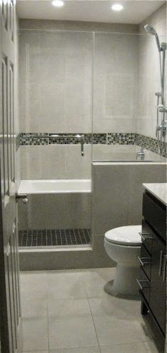 a white toilet sitting next to a bath tub in a bathroom