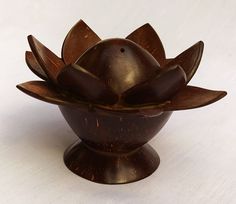 a wooden bowl with an open flower on the top and two petals at the bottom