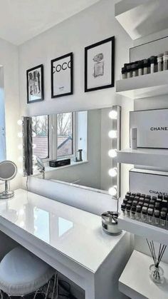 a white counter top sitting under a mirror next to a window with lights on it