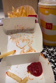 fries and ketchup sit in boxes on a table