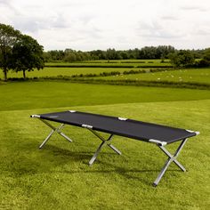 a black table sitting on top of a lush green field