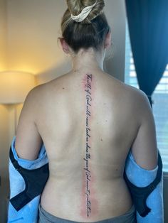 the back of a woman's upper body with writing on her left arm and chest