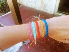 a person's arm with four different colored bracelets on it