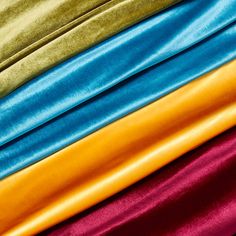 several colors of satin fabric stacked on top of each other in different sizes and shapes