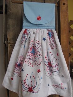 a white dress with red, white and blue stars is hanging on a wooden chair