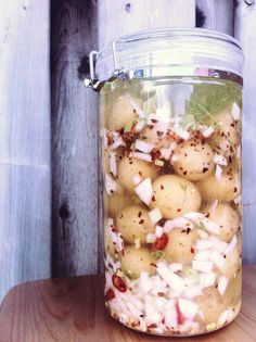 a glass jar filled with potatoes and onions