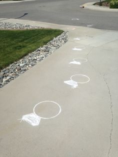 the sidewalk has white chalk drawings on it