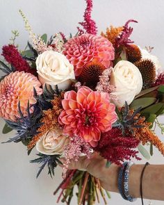 a person holding a bouquet of flowers in their hand