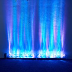 a blue and purple wall with lights on it's sides in front of a white wall