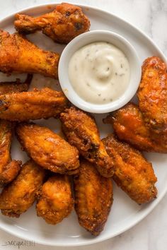 chicken wings with ranch dressing on a white plate