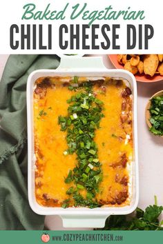 baked vegetarian chili cheese dip in a white casserole dish with green onions and cilantro