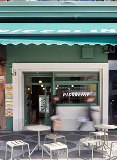 two white chairs sitting in front of a store