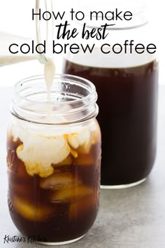 two mason jars filled with cold coffee and ice cream, one has been poured into the jar