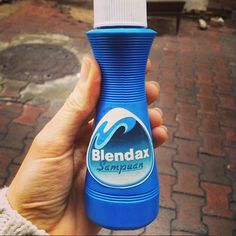 a hand holding a blue bottle with the word blendat on it's side