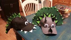 two hats that look like dinosaurs on a table