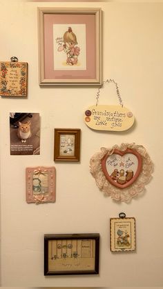 the wall is covered with many different pictures and framed art pieces, including a heart shaped clock