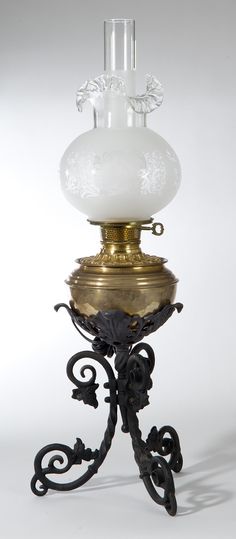 an old fashioned lamp with a white glass shade on it's top and base