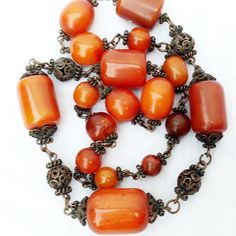 Beautiful Vintage Baltic Amber Barrel Bead & Copper With A Gold Patina Necklace. Large Authentic Baltic Amber Barrel Beads Graduated Into Smaller, Round Amber Beads, & Copper Filigree Spacer Beads With A Dark Gold Patina In Between. Measures Approximately 14" Long. No Clasp, But One Could Be Easily Added. The Largest Bead Is About 1.25" X 1". The Smallest Bead Is About .5" Round.Weighs Around 150 Grams. In Excellent Condition! Rare Vintage Find! Vintage Orange Beaded Necklaces For Formal Occasions, Elegant Orange Beaded Necklaces With Gemstone Beads, Elegant Orange Gemstone Beaded Necklaces, Elegant Orange Gemstone Beads Necklace, Vintage Orange Jewelry With Faceted Beads, Orange Vintage Jewelry With Faceted Beads, Handmade Orange Beads For Jewelry Making, Elegant Orange Carnelian Beaded Necklace, Elegant Orange Necklaces With Polished Beads