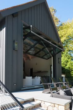 an outdoor living area with couches and chairs in front of a barn style building