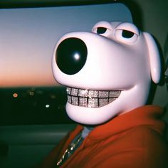 a close up of a person wearing a fake toothy face and smiling with the city lights in the background