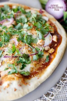 a close up of a pizza on a plate with onions and cilantros