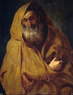 an old man with a book in his hand and wearing a yellow cloak over his head