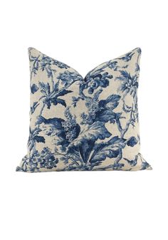 a blue and white floral pillow on a white background